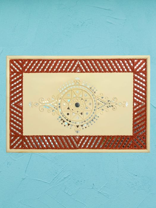 Traditional artistry of mud and mirror design by skilled artisans on yellow circular disc